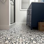 Bathroom with navy vanity and patterned tile
